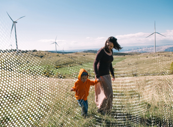 family walking through sand dunes with turbines in background