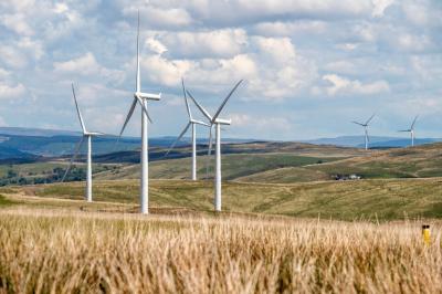 Landscape with rolling countryside, wind turbines, blue sky and clouds